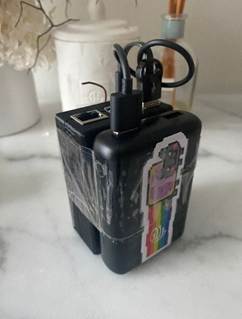 A black device with a sticker on it

AI-generated content may be incorrect.
